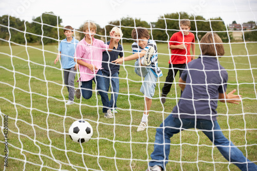 Photo: Boys playing soccer in park Boys playing soccer in park