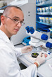 Young scientist dissects samples under binocular