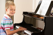 Young boy playing grand piano at home