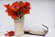 red poppy flowers  on white table and old open Bible