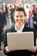 Photo: Female commuter in crowd using laptop Female commuter in crowd using laptop