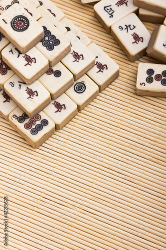 Photo: Old chinese game mahjongg on bamboo mat background Old chinese game mahjongg on bamboo mat background