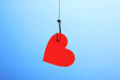 Heart on fish hook on blue background