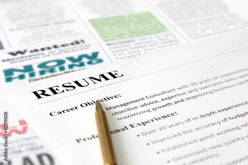 Photo: Closeup of resume with pen on the newspaper Closeup of resume with pen on the newspaper