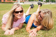 Two woman friends lying on the grass