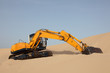 Yellow excavator on a sand dune