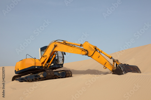 Photo: Yellow excavator on a sand dune Yellow excavator on a sand dune