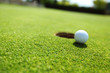 golf ball on lip of cup