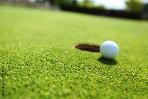 Photo: golf ball on lip of cup golf ball on lip of cup