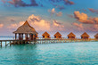 Villa on piles on water at the time sunset