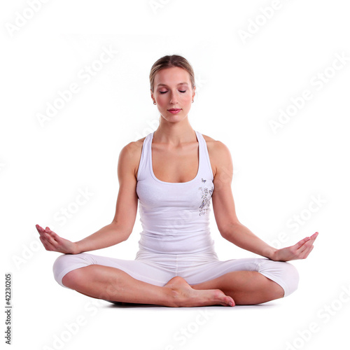 Photo: Young woman practicing yoga, sitting in a lotus position Young woman practicing yoga, sitting in a lotus position