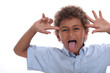 Young boy pulling a face and sticking his tongue out