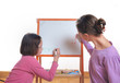 Youngs girls drawing on the white board