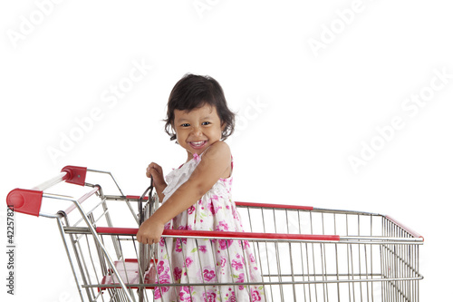 Photo: Cute girl in shopping cart Cute girl in shopping cart
