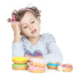 Foto: Little beautiful girl with donuts over white Little beautiful girl with donuts over white