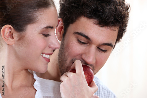 Foto: Young woman and young man eating an apple Young woman and young man eating an apple