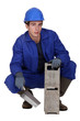Worker holding a cinder block and trowel