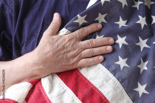 Photo: American flag with the hand of a veteran American flag with the hand of a veteran