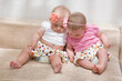 Two sisters, twin baby girls talking and sitting together