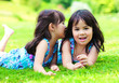 Two little girls telling a secret