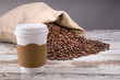 Disposable cup of coffee over vintage wood background