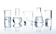 Five laboratory flasks with a clear liquid, isolated