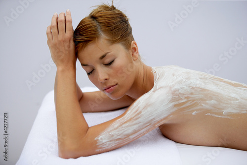 Foto: Woman with cream spread on her back Woman with cream spread on her back