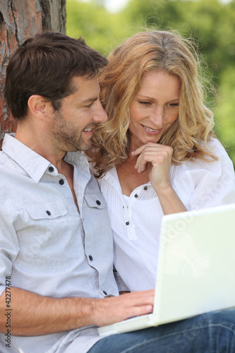 Foto: Couple of Internet users in the park Couple of Internet users in the park