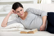 Pregnant woman reading in bed