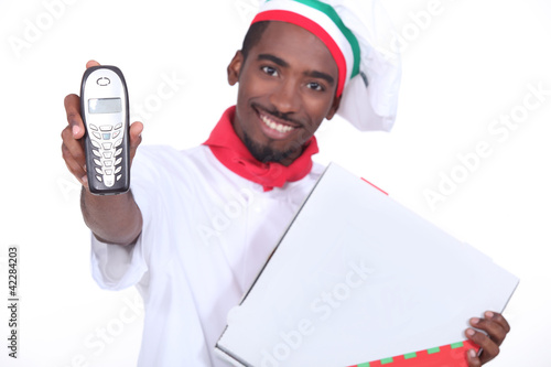 Photo: Smiling Italian chef with a phone and pizza box Smiling Italian chef with a phone and pizza box