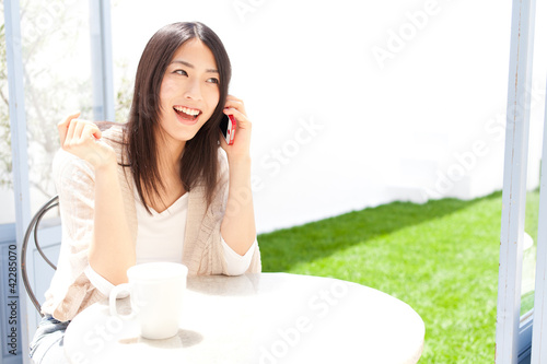 Photo: a young asian woman relaxing in the cafe a young asian woman relaxing in the cafe