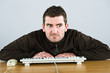 man is squinting in to the monitor