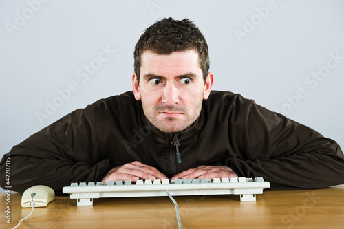 Photo: man is squinting in to the monitor man is squinting in to the monitor