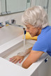 Seniorin macht Wechselbäder im Waschbecken