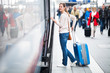 Pretty young woman boarding a train (color toned image)