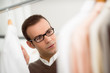 adult man choosing shirt in clothes shop