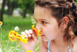 Little girl smelling flower