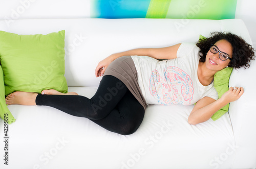 Foto: junge frau liegt relaxt auf dem sofa junge frau liegt relaxt auf dem sofa