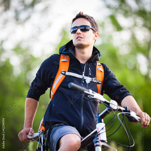 Foto: Handsome young man biking in the countryside Handsome young man biking in the countryside