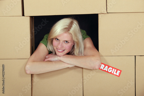 Photo: Woman stood amongst cardboard boxes Woman stood amongst cardboard boxes