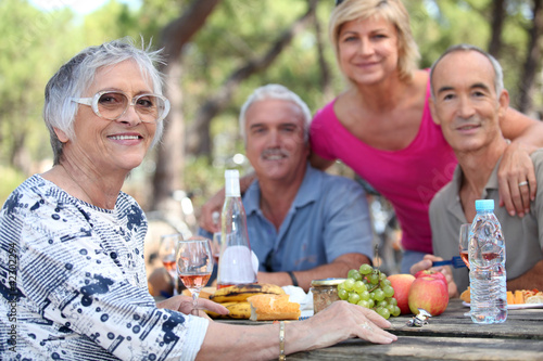 Photo: Senior woman having a picnic with friends Senior woman having a picnic with friends