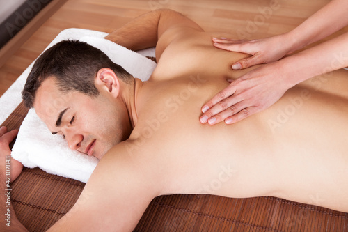 Photo: Young man getting shoulder massage Young man getting shoulder massage