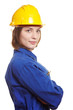 Frau im Blaumann mit Schutzhelm