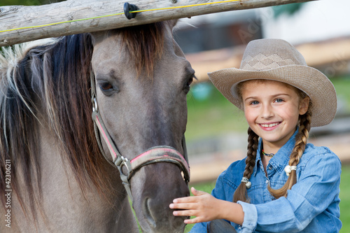Photo: Lovely cowgirl and horse on a ranch Lovely cowgirl and horse on a ranch