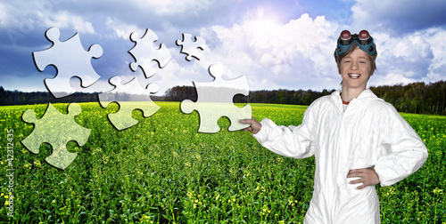 Photo: Young man holding a piece of puzzle against a landscape Young man holding a piece of puzzle against a landscape