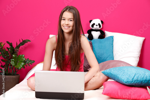 Photo: teenager smiling and using laptop teenager smiling and using laptop
