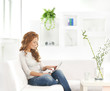 A young Caucasian woman relaxing in a white modern interior