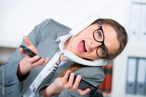 Photo: frau führt mehrere telefongespräche gleichzeitig frau führt mehrere telefongespräche gleichzeitig