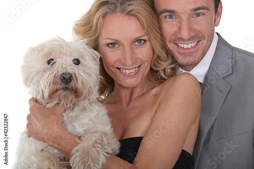 Photo: Couple holding dog. Couple holding dog.