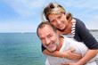 Photo: Portrait of senior man holding woman on his back Portrait of senior man holding woman on his back